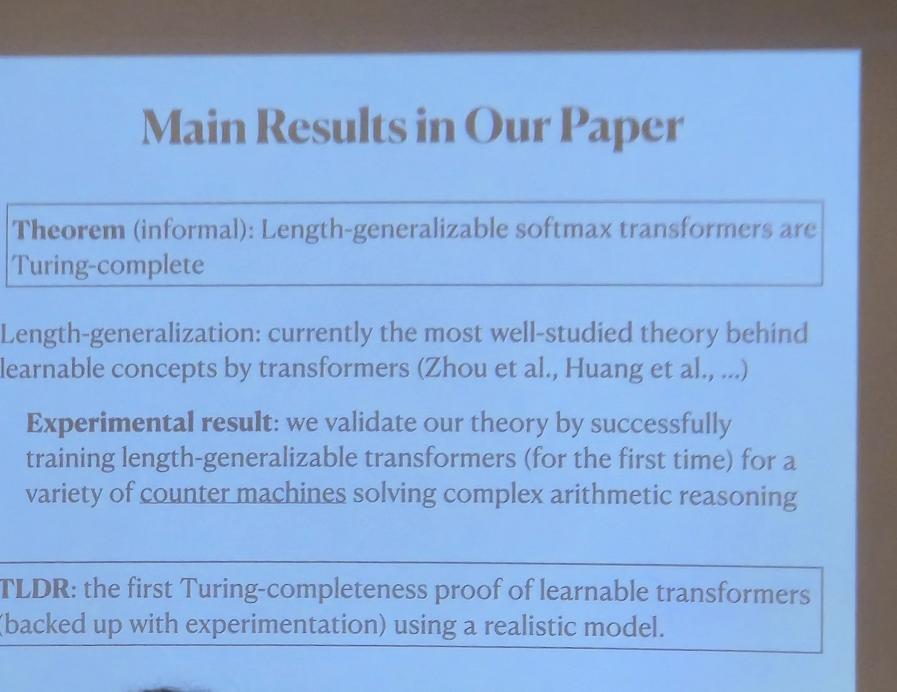 Projected slide titled 'Main Results in Our Paper' with two text blocks. The first is labeled Theorem (informal) and states that length-generalizable softmax transformers are Turing-complete. The second is labeled Experimental result and describes training length-generalizable transformers that recognize arithmetic languages. A TLDR paragraph at the bottom summarizes the first Turing-completeness proof of learnable transformers backed up with experiments.
